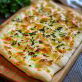 Cheesy Garlic Butter Flatbread herbs on a wooden board.