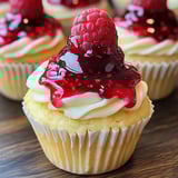 A cupcake with a raspberry on top.